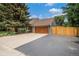 Home exterior with a paved driveway leading up to a two-car garage, with a well-maintained lawn at 14887 W 49Th Pl, Golden, CO 80403