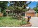 Charming brick home featuring a well-manicured front yard, mature landscaping, and an attached two-car garage at 14887 W 49Th Pl, Golden, CO 80403