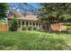 Lovely brick home with a lush green lawn, mature shade trees, and an attached garage; a welcoming and picturesque scene at 14887 W 49Th Pl, Golden, CO 80403