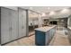 Spacious kitchen with sleek gray cabinets, a central island, stainless steel appliances, and a view of the living area at 14887 W 49Th Pl, Golden, CO 80403