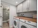 Convenient laundry area featuring modern appliances, cabinetry for storage, and access to the bathroom at 14887 W 49Th Pl, Golden, CO 80403