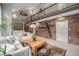 Stylish living room with an open floor plan, featuring a brick accent wall, modern staircase, and ample natural light at 14887 W 49Th Pl, Golden, CO 80403
