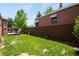 A charming backyard with green grass and a wood fence providing privacy at 3036 Birch St, Denver, CO 80207