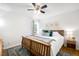 Comfortable bedroom with wooden sleigh bed, decorative pillows, area rug, and light-filled window at 3036 Birch St, Denver, CO 80207