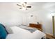 Bright bedroom showcasing wooden dresser, ceiling fan, area rug, and a comfortable bed with accent pillows at 3036 Birch St, Denver, CO 80207