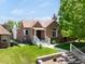Charming brick home featuring a well-manicured lawn, inviting porch, and classic architectural details at 3036 Birch St, Denver, CO 80207