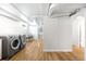 Bright laundry area with newer washer and dryer, and wooden flooring at 3036 Birch St, Denver, CO 80207