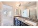 Bathroom features double granite vanity, modern fixtures, and walk-in shower with a white tile surround at 12843 W Nevada Pl, Lakewood, CO 80228
