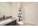 Bathroom featuring granite counters, dark cabinets, shower and tub combination, and decorative shower curtain at 12843 W Nevada Pl, Lakewood, CO 80228