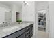 Primary bathroom with dual vanity, glass shower, and walk-in closet with custom storage at 12843 W Nevada Pl, Lakewood, CO 80228