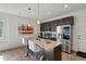 Modern kitchen with stainless appliances, a granite island with barstool seating, and dark wood cabinets at 12843 W Nevada Pl, Lakewood, CO 80228