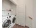 Bright laundry room features side by side washer and dryer and shelving for storage at 12843 W Nevada Pl, Lakewood, CO 80228