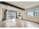Open living room with wood floors, beamed ceilings and a glass garage door to the patio at 12843 W Nevada Pl, Lakewood, CO 80228