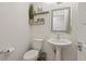 Half bath featuring a pedestal sink, floating shelves, and decorative wall art at 12843 W Nevada Pl, Lakewood, CO 80228