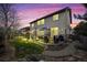 Well-lit backyard featuring a stone patio, seating, and lush greenery perfect for evening relaxation and outdoor enjoyment at 6475 S Newcastle Way, Aurora, CO 80016