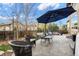 Serene backyard oasis with stone patio, comfortable seating, umbrella, and lush landscaping perfect for outdoor living at 6475 S Newcastle Way, Aurora, CO 80016