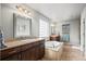 Bathroom featuring double sinks, a separate shower, a soaking tub, and tile flooring at 6475 S Newcastle Way, Aurora, CO 80016