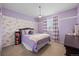 Bedroom featuring a queen bed, floral wallpaper, chair railing, and light purple walls at 6475 S Newcastle Way, Aurora, CO 80016