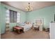 Calm bedroom featuring a light blue paint, a bed, a vanity table, and natural light at 6475 S Newcastle Way, Aurora, CO 80016