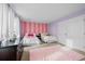 Bedroom featuring two twin beds, striped accent wall, pink carpet and white trim at 6475 S Newcastle Way, Aurora, CO 80016