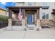 Inviting front porch with stone columns, American flag, and a blue front door with wreath detail at 6475 S Newcastle Way, Aurora, CO 80016