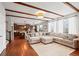Bright, open concept living room showing kitchen with adjacent large sectional couch and wood floors at 6475 S Newcastle Way, Aurora, CO 80016