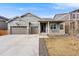 Charming exterior features a welcoming front porch, well-maintained lawn, and a three car garage at 2187 Pineywoods St, Mead, CO 80542