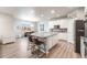 Open kitchen features stainless appliances, granite countertops, and laminate floors at 2187 Pineywoods St, Mead, CO 80542