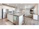 Open concept kitchen island and stainless appliances overlooking the fireplace and living room at 2187 Pineywoods St, Mead, CO 80542