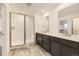 Bathroom featuring dual sinks, gray cabinets, marble floor tile, and a glass enclosed shower at 39816 Floyd St, Elizabeth, CO 80107