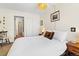 Neutral bedroom featuring a large bed, wooden floors, and a view into an ensuite bathroom at 1390 N Emerson St # 406, Denver, CO 80218