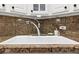 Close-up of a clean kitchen sink with a chrome faucet and neutral granite backsplash at 1390 N Emerson St # 406, Denver, CO 80218