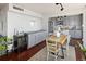 Dining area with a wooden table, white chairs, and an adjacent kitchen with stainless steel appliances at 790 N Washington St # 1210, Denver, CO 80203