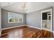 Bedroom featuring wood floors, large window, and stylish light fixture at 17 Polo Club Dr, Denver, CO 80209
