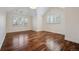 Bright bedroom featuring hardwood floors, large windows, and white walls at 17 Polo Club Dr, Denver, CO 80209