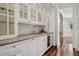 Butler pantry features glass cabinets, granite countertops, wine storage and a sink at 17 Polo Club Dr, Denver, CO 80209