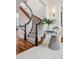 Elegant home foyer featuring a curved staircase, hardwood floors, and decorative accents at 17 Polo Club Dr, Denver, CO 80209