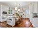 Bright, white kitchen with a large island, stainless steel appliances, and hardwood floors at 17 Polo Club Dr, Denver, CO 80209