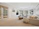Bright living room with a neutral color palette, built-in shelving, and a wall of windows providing natural light at 17 Polo Club Dr, Denver, CO 80209