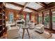 Warm, wood-paneled living room with a fireplace, built-in seating, and doors to the outside at 17 Polo Club Dr, Denver, CO 80209