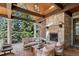 Covered outdoor living space featuring a fireplace, comfortable seating, and a wood ceiling at 17 Polo Club Dr, Denver, CO 80209