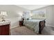 Comfortable bedroom with soft green bedding, bedside tables, and calming artwork at 301 Widgeon Ln, Longmont, CO 80503