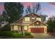 Charming two-story home with a well-manicured lawn and a two-car garage in a quiet neighborhood at sunset at 301 Widgeon Ln, Longmont, CO 80503