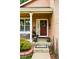 A welcoming front porch with a beautiful flower wreath on a red door and decorative plants at 301 Widgeon Ln, Longmont, CO 80503