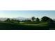 Picturesque golf course featuring green rolling hills, mature trees, and mountain views in the background at 301 Widgeon Ln, Longmont, CO 80503