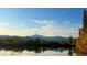 Scenic lake view with trees in the foreground, reflected in the water, and mountains in the distance at 301 Widgeon Ln, Longmont, CO 80503