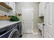 Well-lit laundry room featuring modern washer and dryer, storage cabinets and convenient utility sink at 301 Widgeon Ln, Longmont, CO 80503