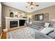 Cozy living room with a fireplace, TV, built-in shelving, and a comfortable gray sectional at 301 Widgeon Ln, Longmont, CO 80503