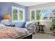 Bright bedroom featuring a stylish accent chair and natural light filtering through shuttered windows at 301 Widgeon Ln, Longmont, CO 80503