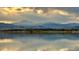 Panoramic waterfront view featuring a serene lake reflecting a dramatic sky and distant mountains at 301 Widgeon Ln, Longmont, CO 80503